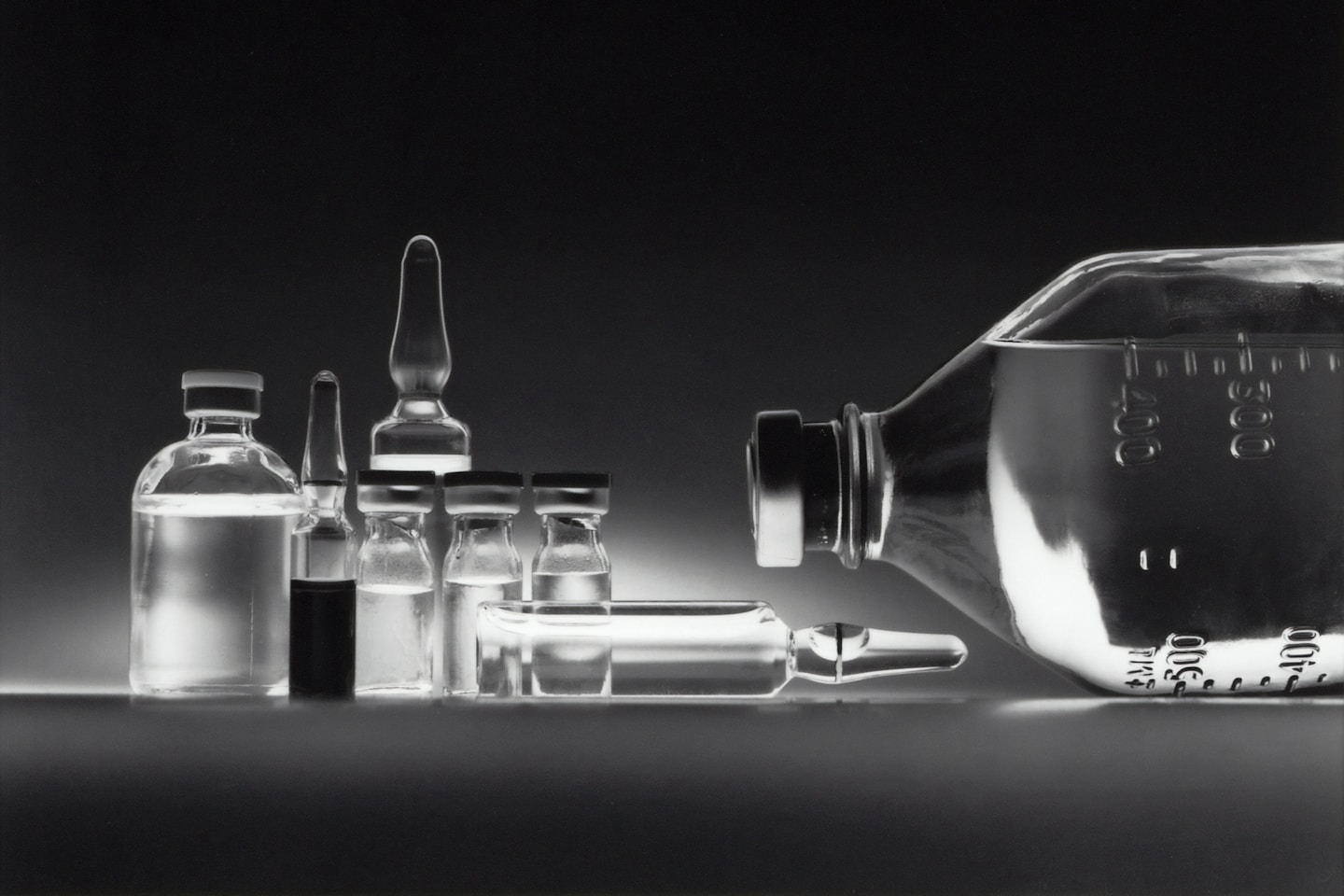 Variety of chemotherapy drugs in vials and an IV bottle.